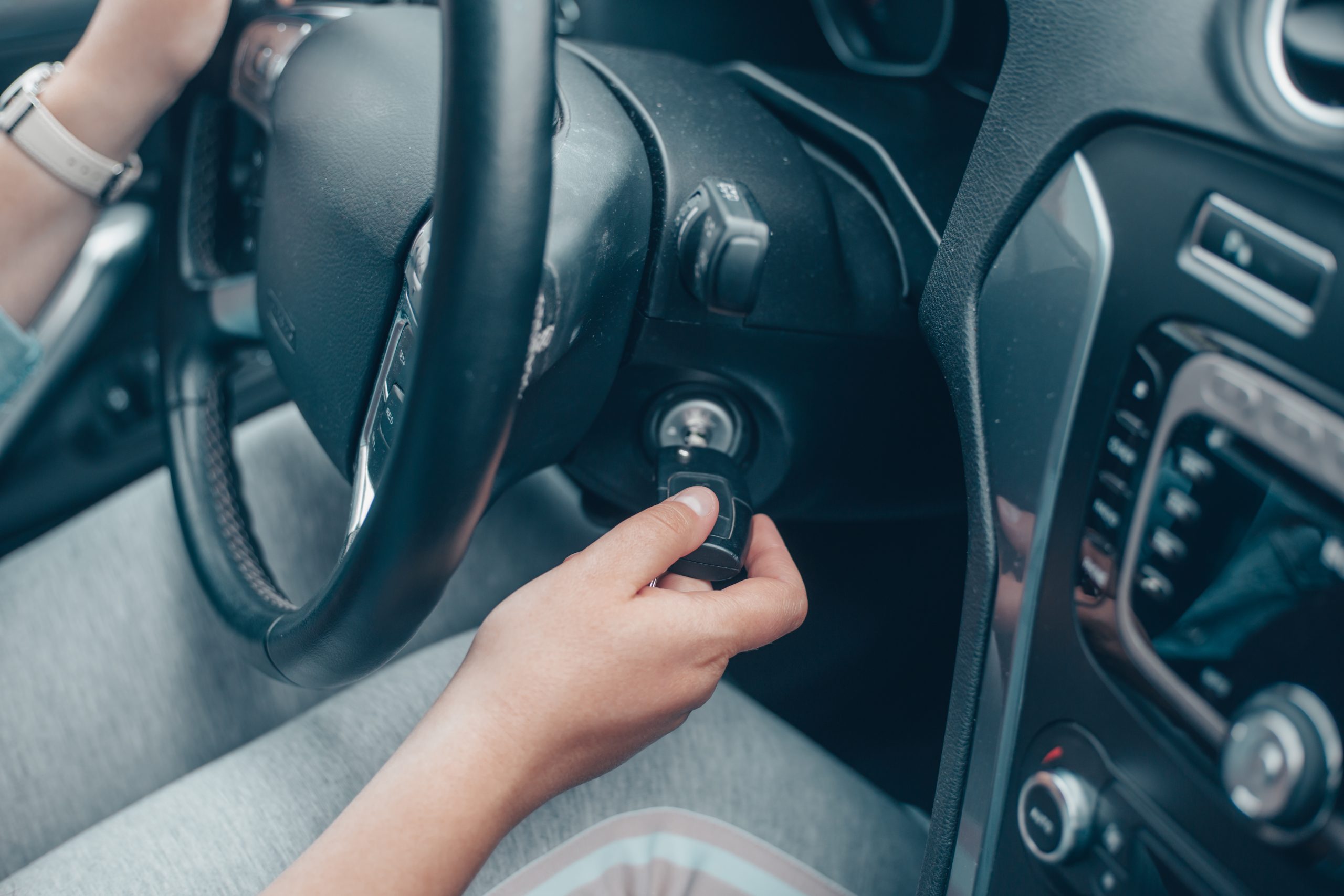 Person putting keys into car ignition