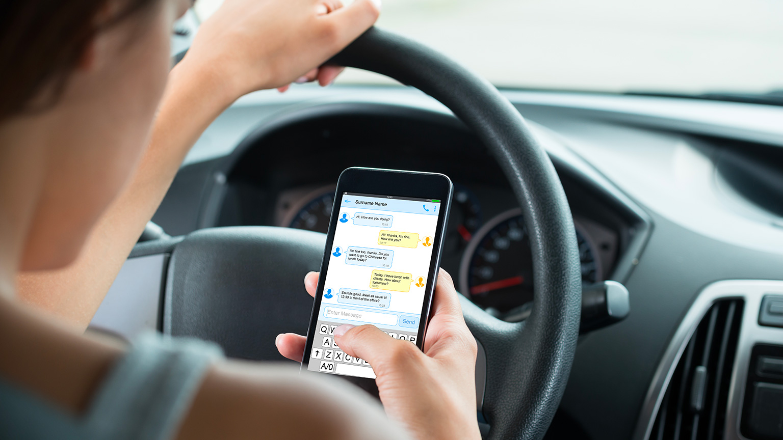 Woman texting on phone in car