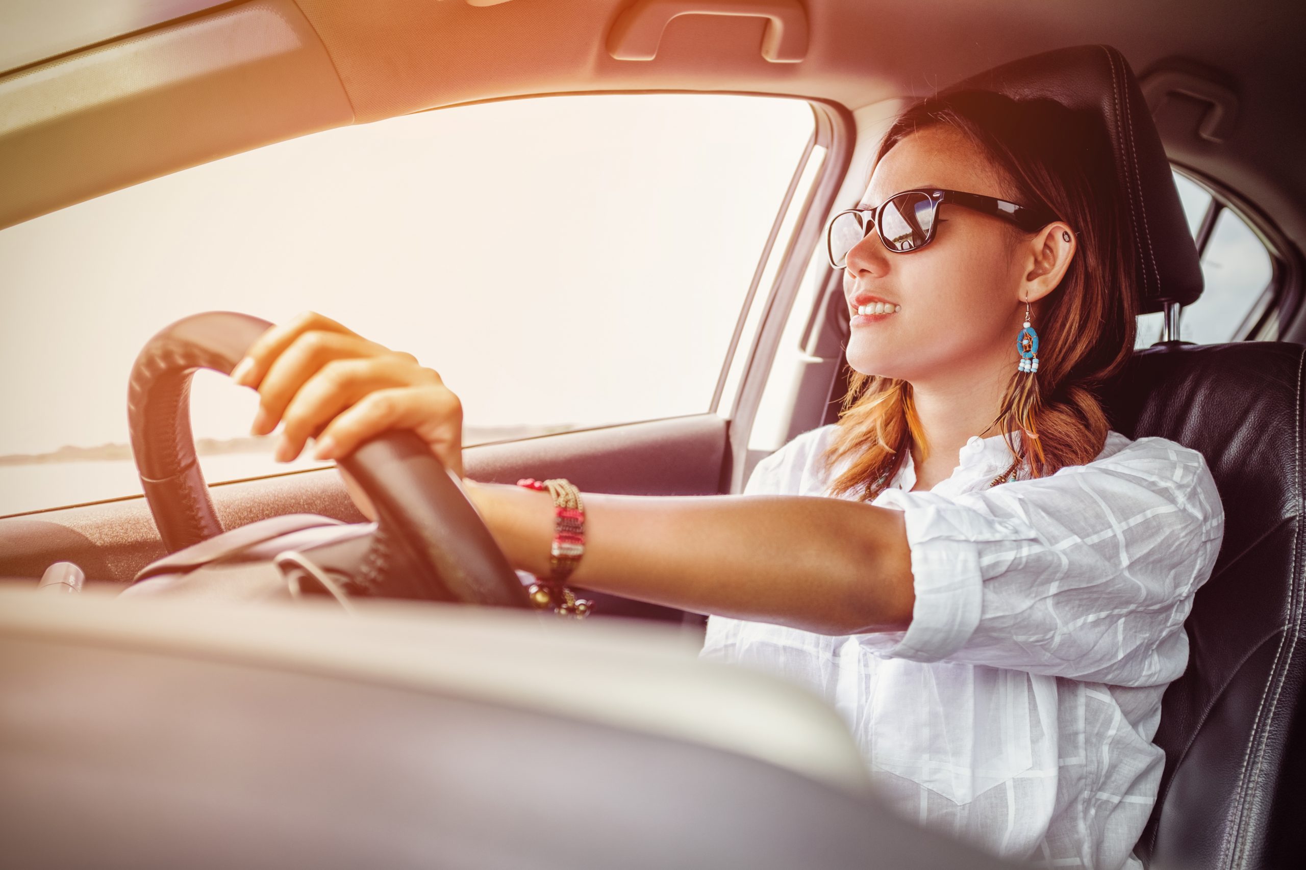 Woman driving in car wearing sunglasses