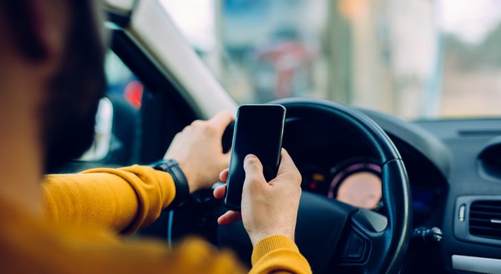 Person holding phone in car